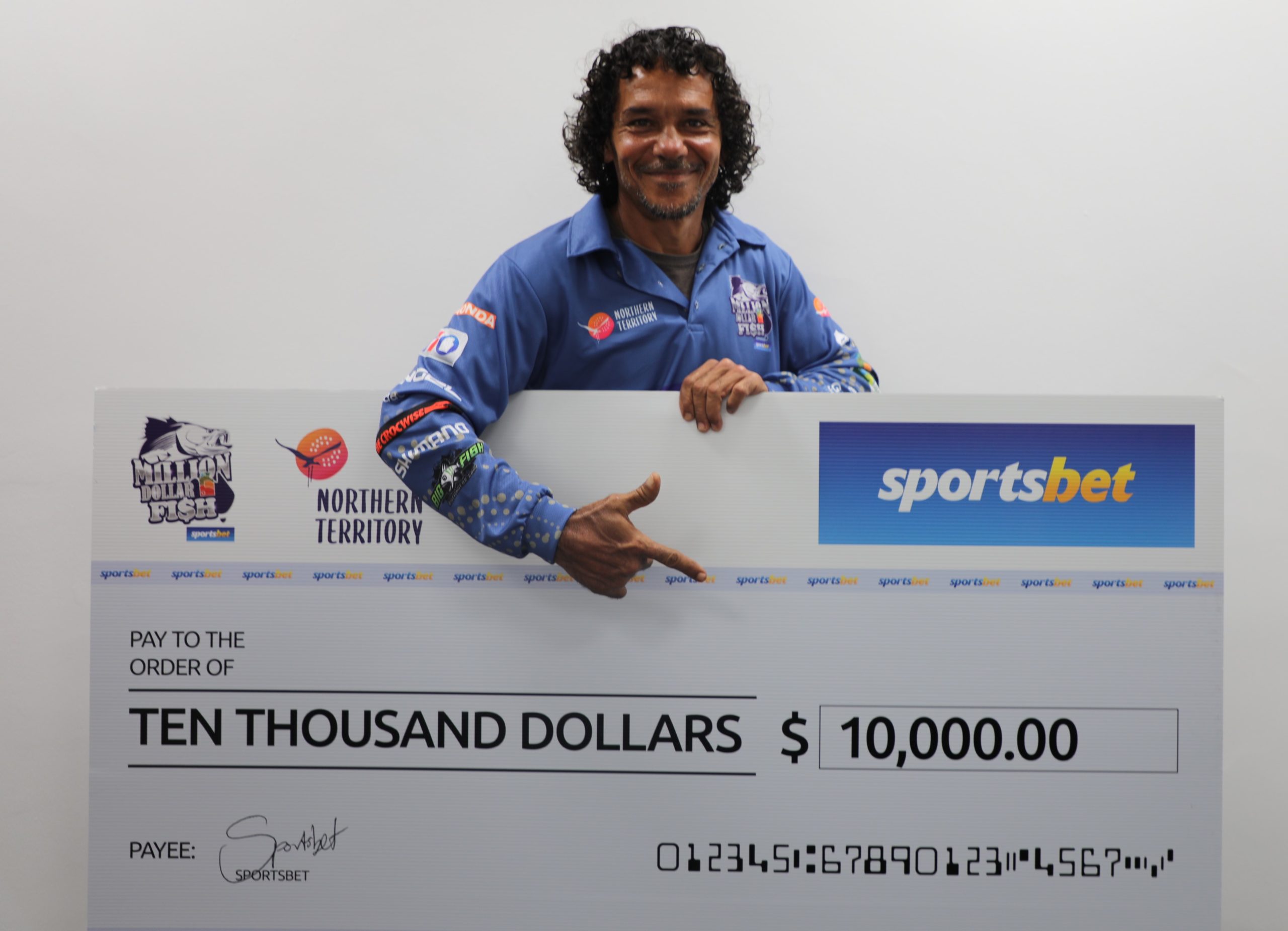 Man smiling with $10,000 cheque