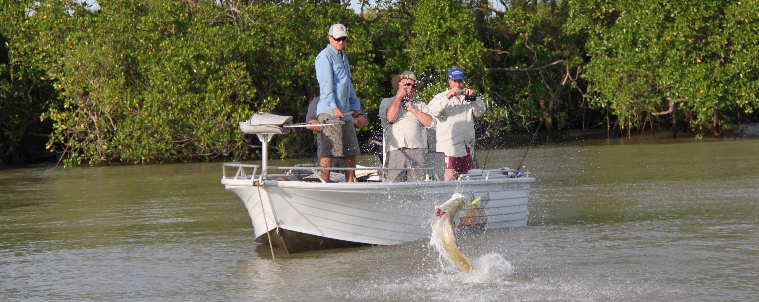 Group of people fishing for barramundi from a boat