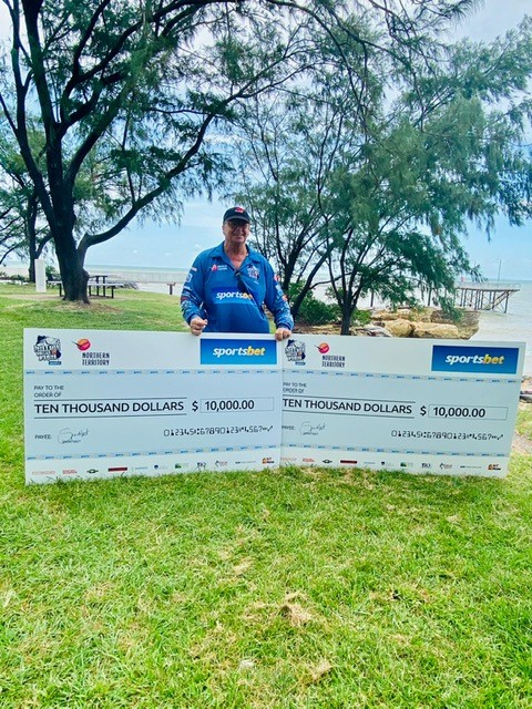 David Ashfield with his two $10,000 cheques
